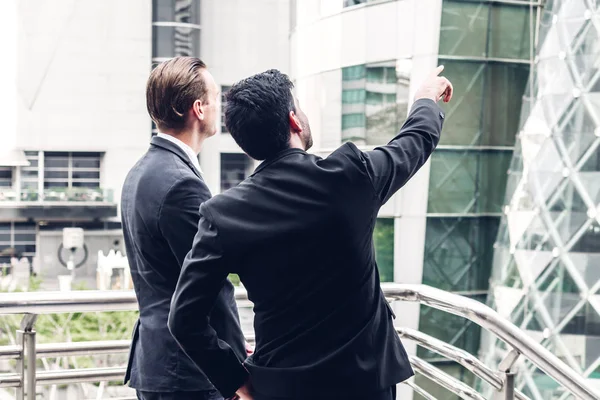 Dois homens de negócios sorridentes em terno preto conversando e andando — Fotografia de Stock