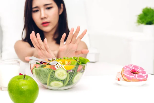 Mujer haciendo elección entre ensalada saludable y choco bomba de calorías — Foto de Stock