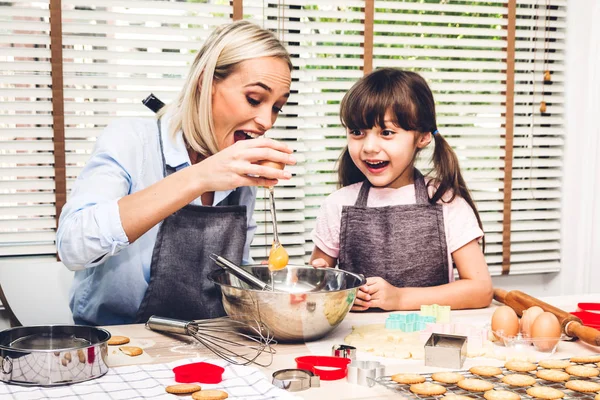 Mother and daugthter having fun cooking togather and learning to