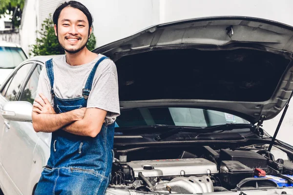Professional car mechanic in uniform with crossed arms fixing a — Stock Photo, Image