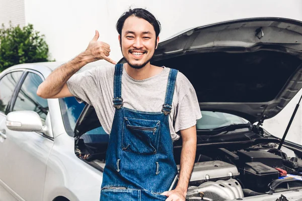 Professional car mechanic in uniform  fixing a car engine and re — Stock Photo, Image