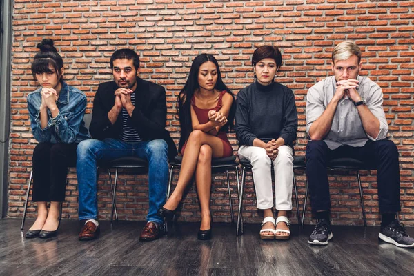 Gruppe von Geschäftsleuten, während sie auf einem Stuhl sitzen und auf Arbeit warten — Stockfoto