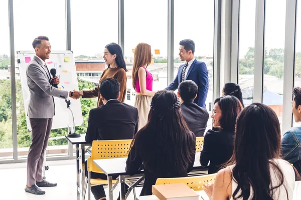 Businessman standing in front of group of people in consulting m — Stock Photo, Image