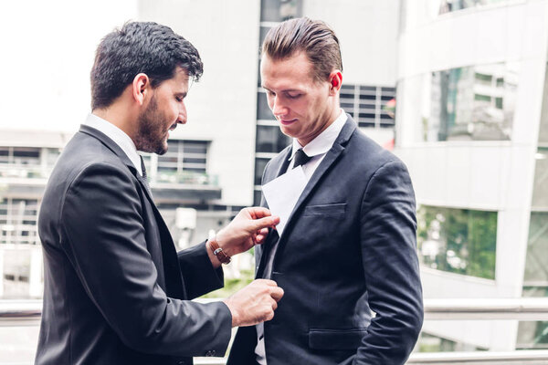 Бизнесмен дает деньги в конверте. Концепция коррупции
