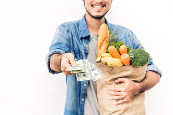 Мужчина держит бумажный пакет с фруктами и овощами на белом — стоковое фото