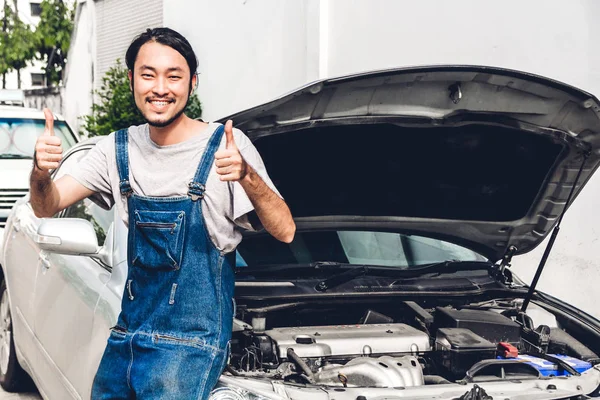 Professional car mechanic in uniform smiling with thumb up fixin — Stock Photo, Image
