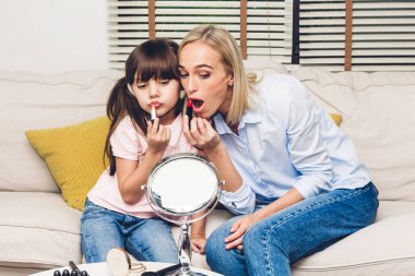 Eğleniyor ve makyaj kozmetik yapıyor küçük kızı annesiyle