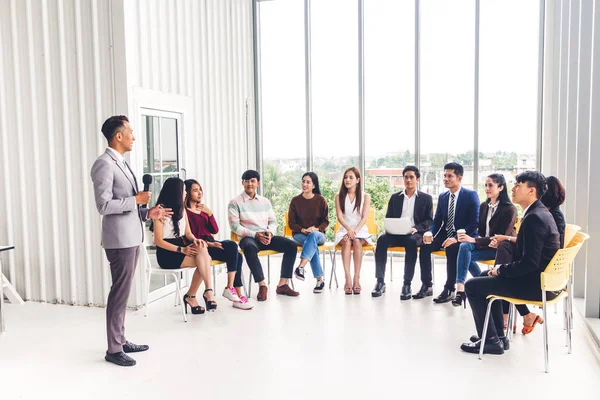 Businessman standing in front of group of people in consulting m — Stock Photo, Image