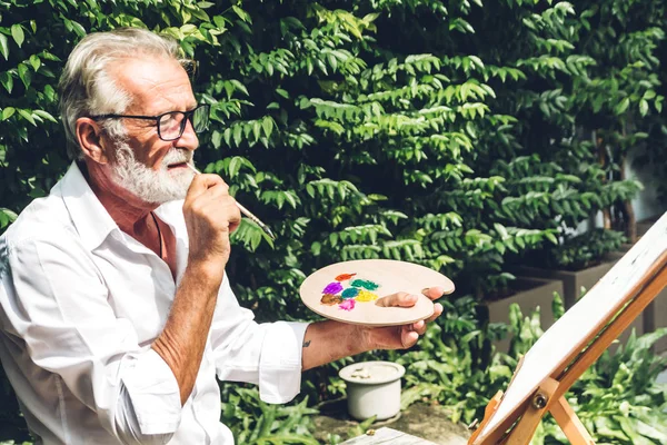 Felice sorridente anziano anziano uomo artista disegno su tela con col — Foto Stock