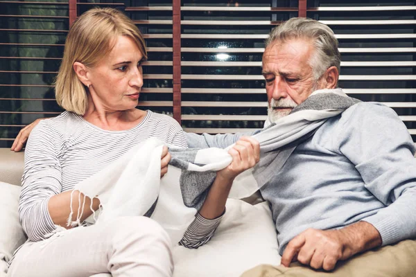 Pareja mayor relajándose y hablando juntos sentados en el sofá en l — Foto de Stock