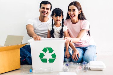 Mutlu gülümseyen aile boş geri dönüşüm plastik koyarak eğlenmek 