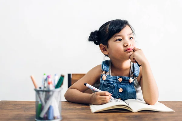 Okul çocuk küçük kız öğrenme ve kalem ile deftere yazma — Stok fotoğraf