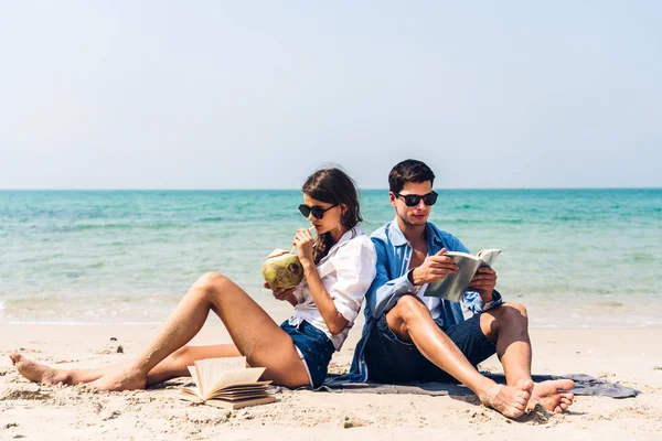 Giovane coppia bere succo di cocco e la lettura di un libro sulla tr — Foto Stock