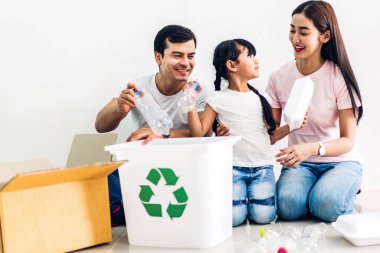 Mutlu gülümseyen aile boş geri dönüşüm plastik koyarak eğlenmek 