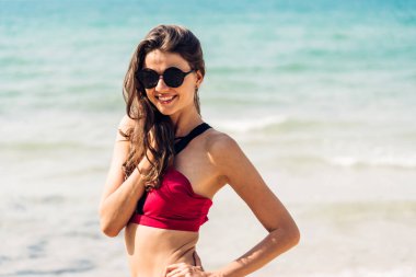 Tropik üzerinde kırmızı bikini gülümseyen kadın gevşeme portresi