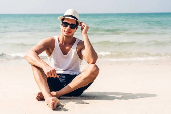 Sonriente hombre guapo relajarse en gafas de sol y sombrero de paja en el tr —  Fotos de Stock