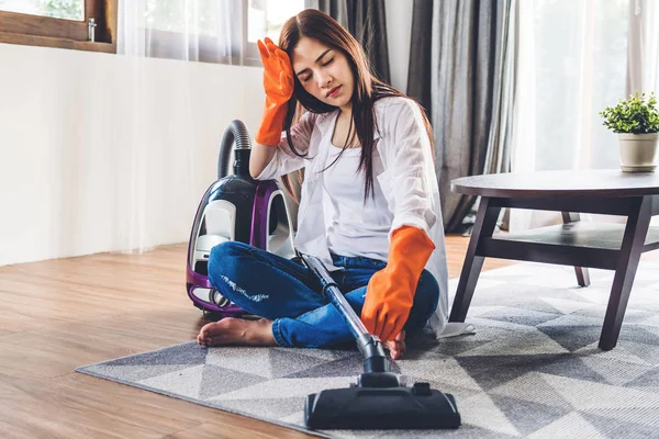 Junge Frau in Schutzhandschuhen putzt Haus mit Staubsauger — Stockfoto