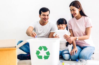 Mutlu gülümseyen aile boş geri dönüşüm plastik koyarak eğlenmek 