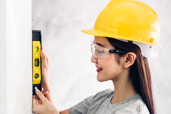 Ung kvinna konstruktion ingenjör i en gul hjälm som arbetar och — Stockfoto