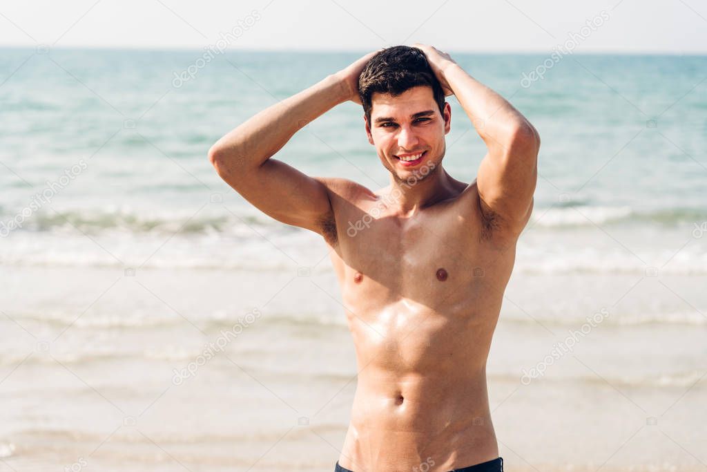 Portrait of smiling handsome sexy man showing muscular fit body 