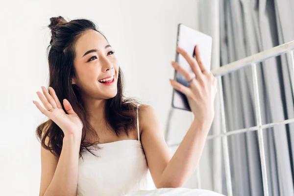 Mujer feliz que relaja usando el ordenador tableta en la cama en home.te —  Fotos de Stock