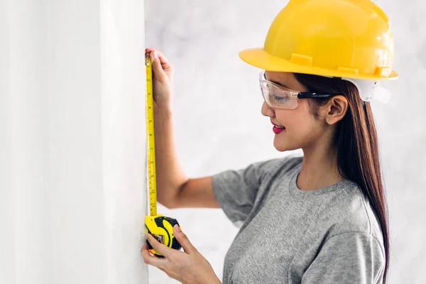 Mujer joven ingeniero de construcción en un casco amarillo de trabajo y — Foto de Stock