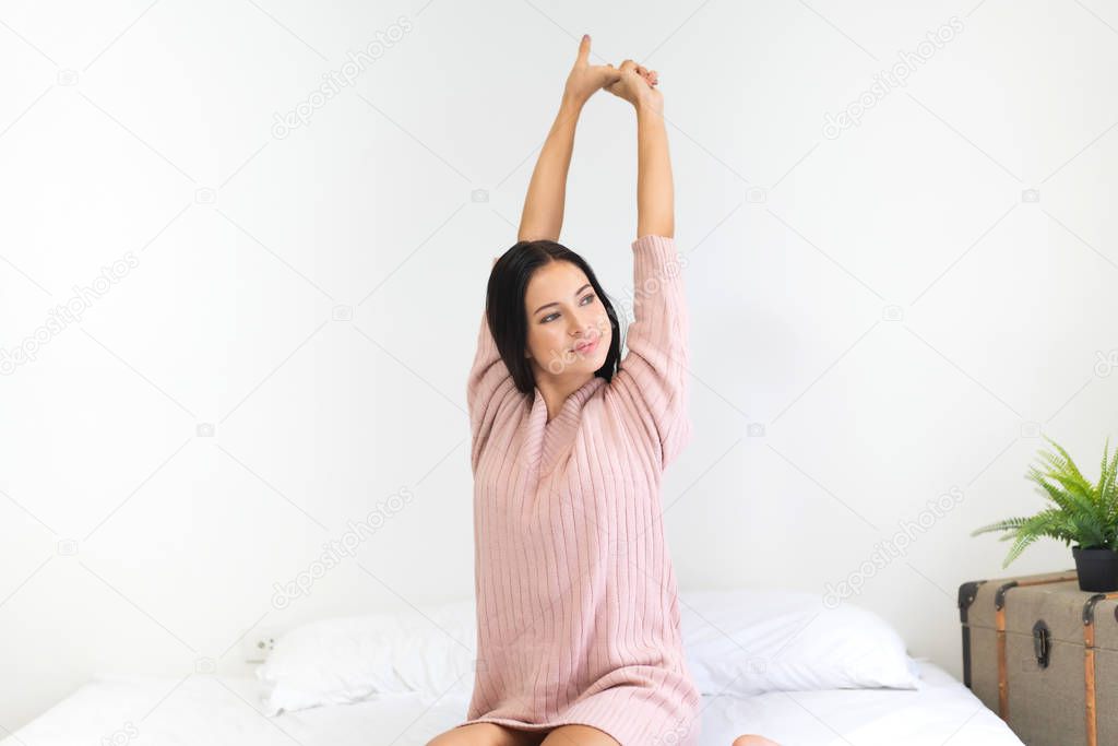 Woman stretching happy and relaxed after wake up in the morning 