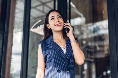 F ayakta iken çalışan ve cep telefonu kullanan iş kadını