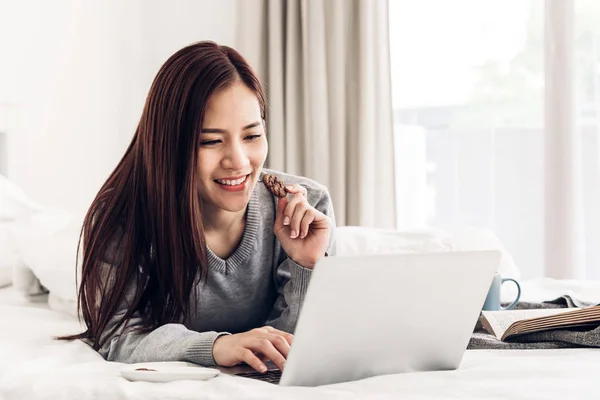 Young woman relaxing and drinking cup of hot coffee or tea using — Stock Photo, Image