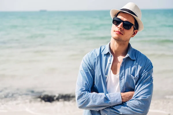 Sonriente hombre guapo relajarse en gafas de sol y sombrero de paja en el tr —  Fotos de Stock