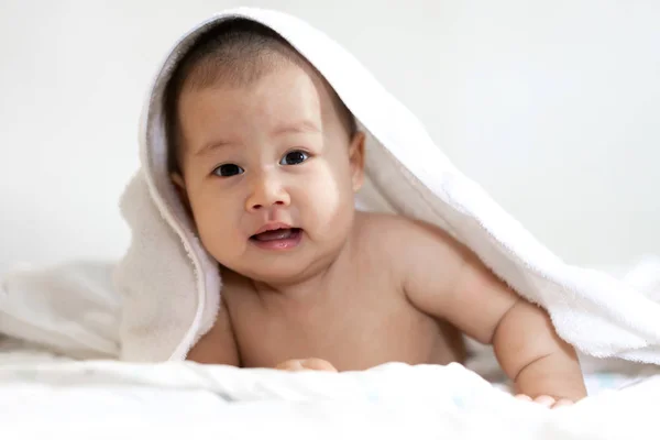 お風呂上のタオルの下でリラックス幸せな笑顔の赤ちゃんの肖像画 — ストック写真