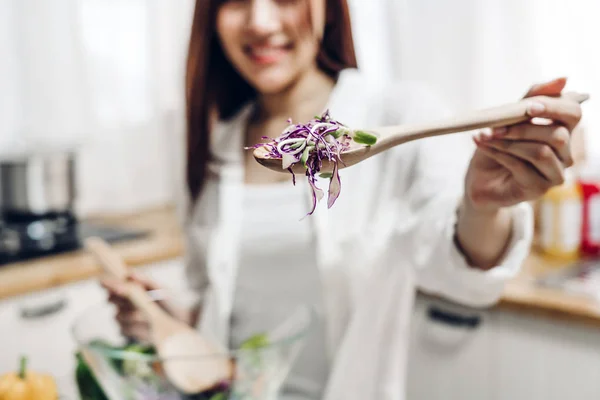Frau kocht Salat in Küche — Stockfoto
