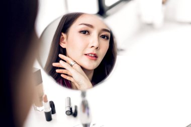 Gülümseyen genç güzel kadın taze sağlıklı cilt mirr bakıyor