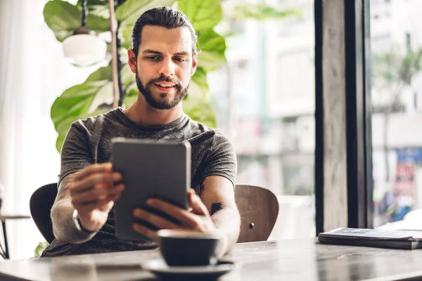 Knappe bebaarde hipster man ontspannen met behulp van Tablet computer citru — Stockfoto