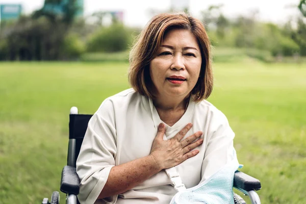 Взрослые женщины азиатского возраста сидят в инвалидном кресле с грудной клеткой — стоковое фото