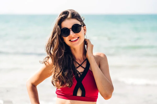 Портрет улыбающейся женщины, отдыхающей в красном бикини на тропике — стоковое фото