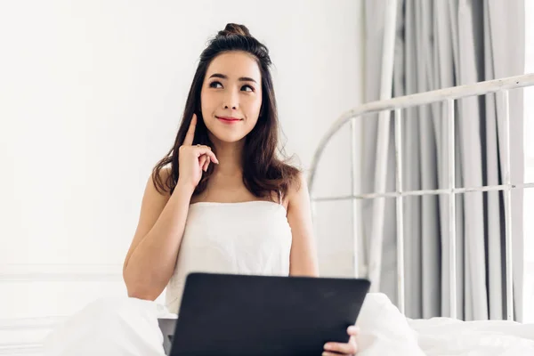 Mujer joven que se relaja con el ordenador portátil en el bedroom.woman —  Fotos de Stock