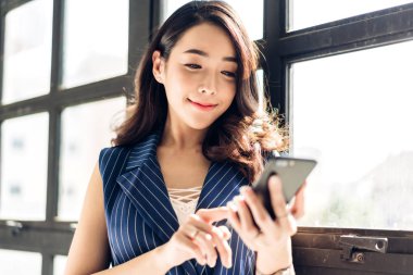 O ayakta iken çalışan ve cep telefonu kullanan iş kadını