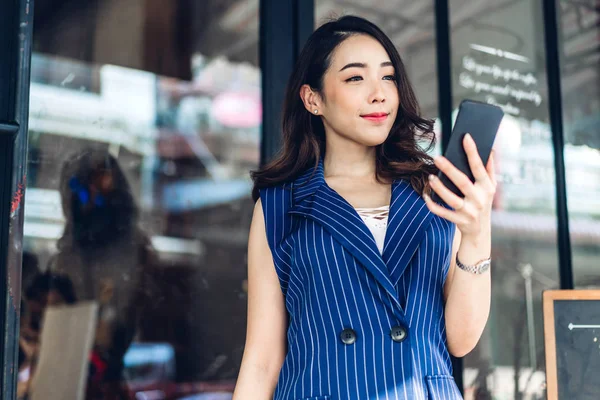 Бізнес-леді працює і використовує мобільний телефон, стоячи в f — стокове фото
