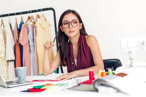 Lächelnde asiatische Modedesignerin arbeitet mit Laptop-Computer — Stockfoto