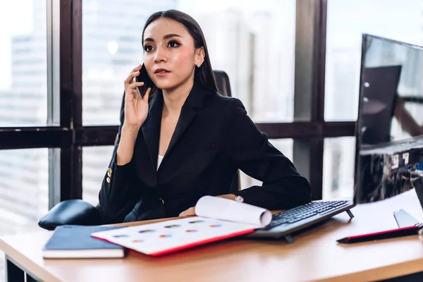 Geschäftsfrau im eleganten schwarzen Anzug arbeitet und nutzt Smartphone — Stockfoto