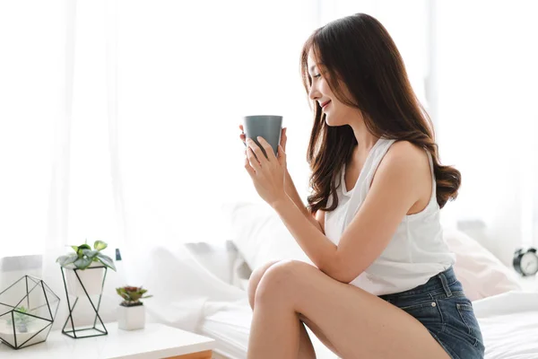 Mujer tomando café en el dormitorio por la mañana —  Fotos de Stock