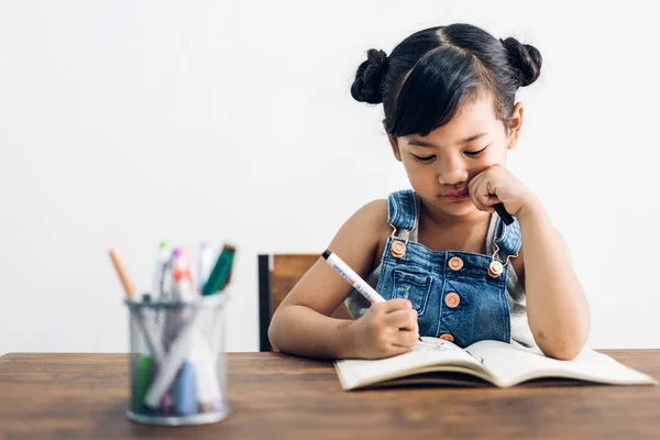 Skolan Kid liten flicka lärande och skriva i anteckningsbok med penna — Stockfoto