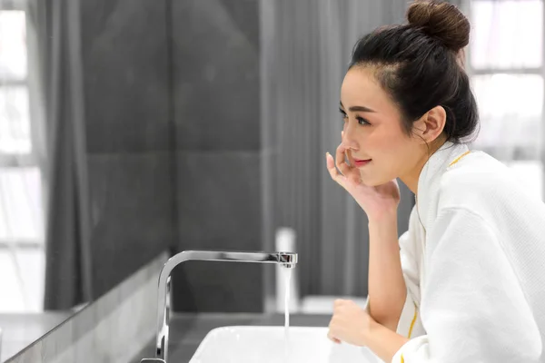 Hermosa joven asiático mujer lavado limpio cara con agua y sm —  Fotos de Stock