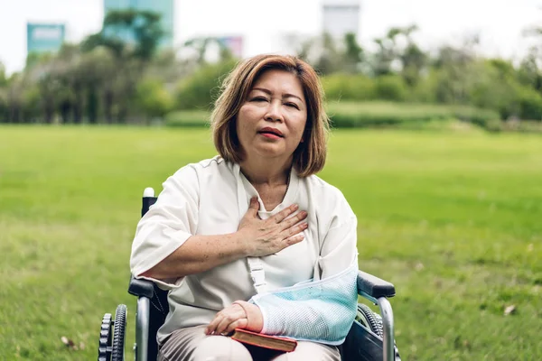 亚洲老年老年妇女坐在轮椅上,胸前有胸膛 — 图库照片