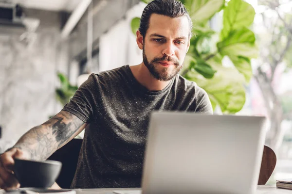 Bonito homem hipster barbudo uso e olhando para o computador portátil — Fotografia de Stock