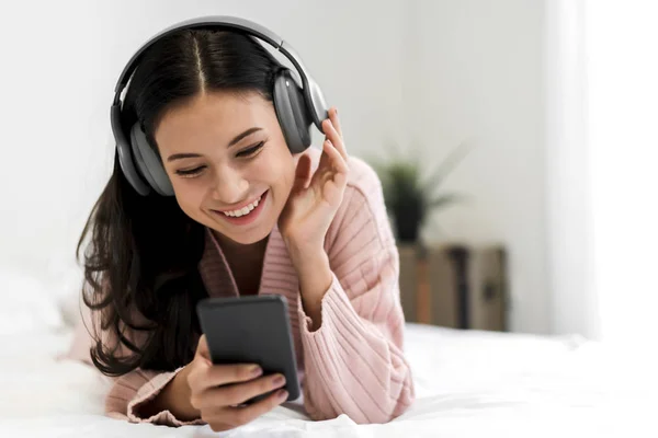 Hermosa joven mujer relajante escuchando música con auriculares —  Fotos de Stock