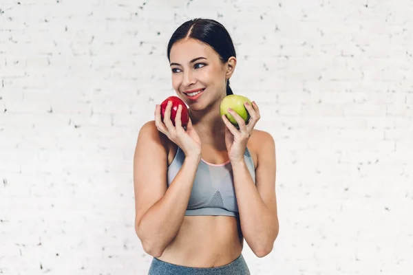 흰색 벽에 고립 된 빨간 사과를 들고 스포츠 건강한 여자 b — 스톡 사진