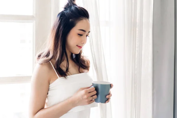 Woman drinking coffee in bedroom in the morning — Stock Photo, Image