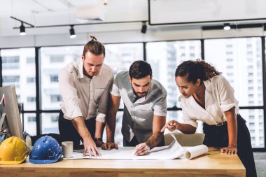 Takım mühendis inşaat araçları ile masada çalışıyor